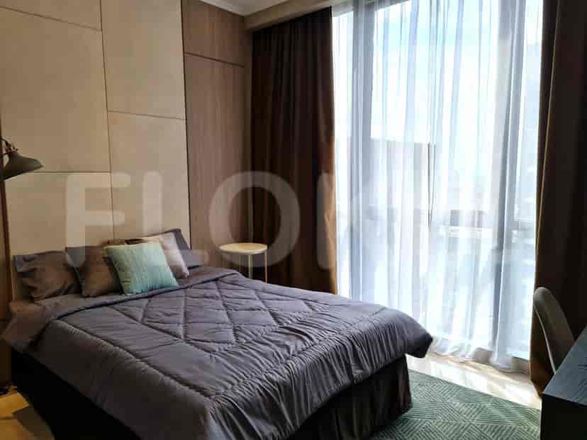 A bedroom with a large bed, stylish curtains, and a view of the city.