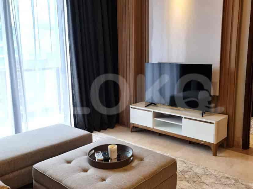 Contemporary living room with a mounted TV, ottoman seating, and a stylish design.