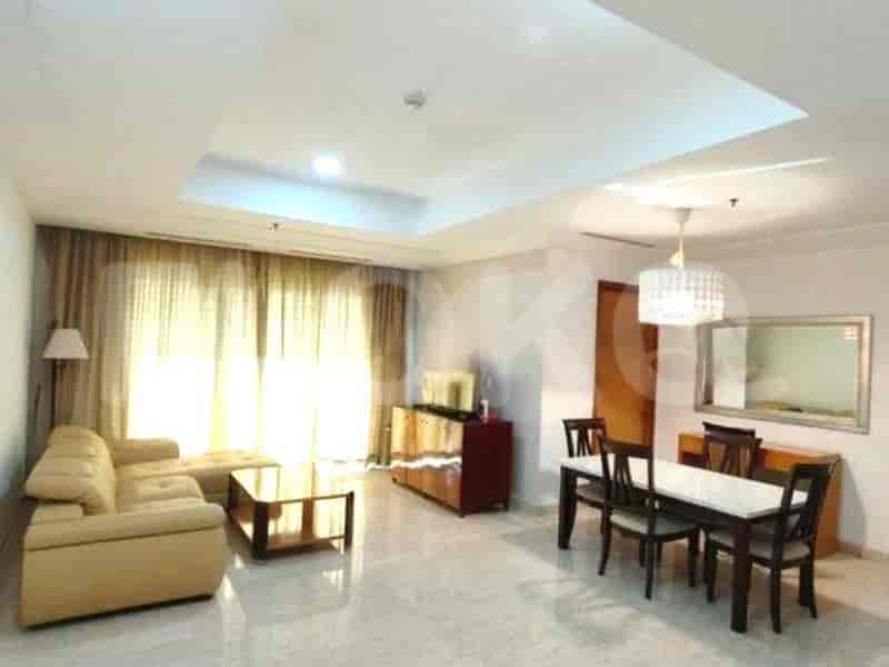 Spacious living room with a sofa, coffee table, dining area, and large windows.