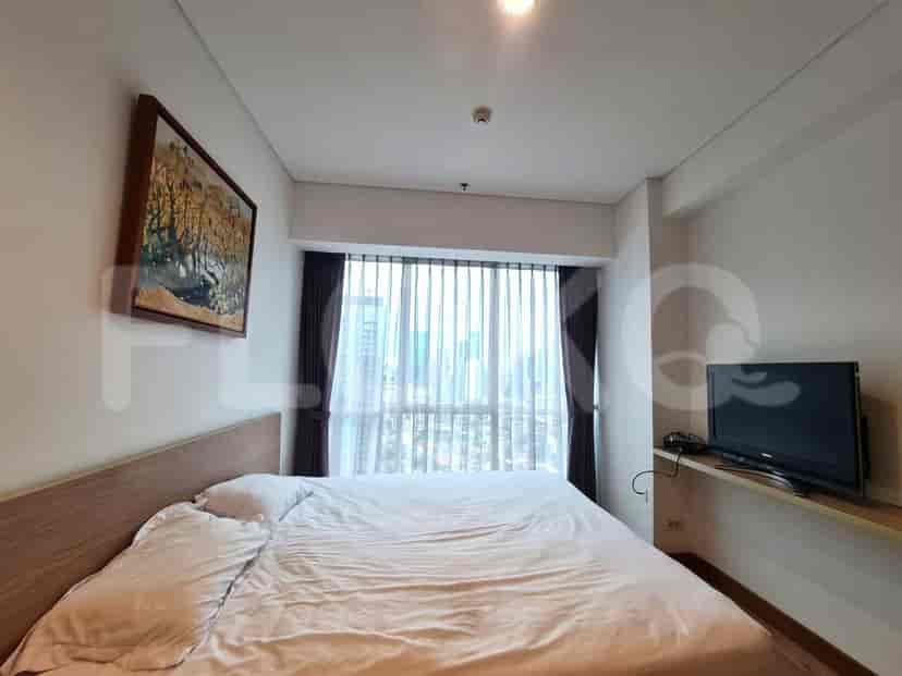 Bedroom with a large bed, artwork, and a window with city view.