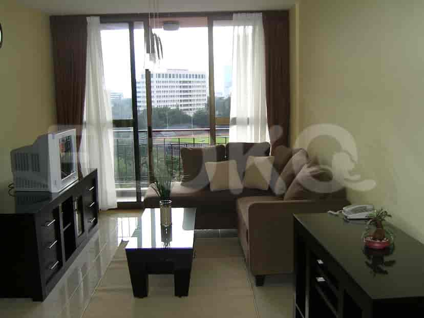 Another view of the living room highlighting the sofa, entertainment unit, and window view.