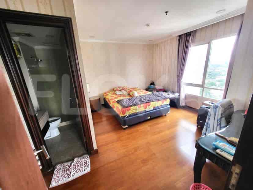 A bedroom with a bed, side tables, and a view of the exterior.