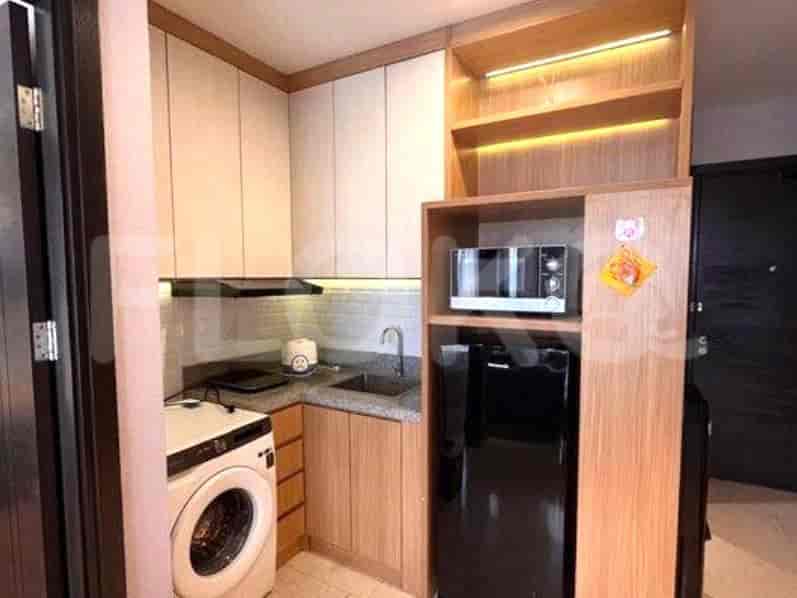 Dapur ringkas dengan lemari, peralatan, dan area makan kecil.