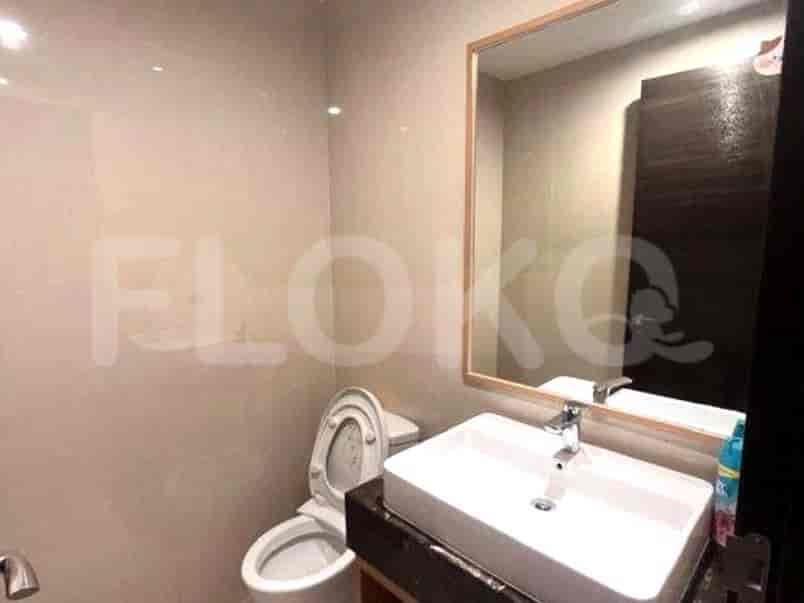 Kamar mandi dengan toilet, wastafel, dan cermin besar.