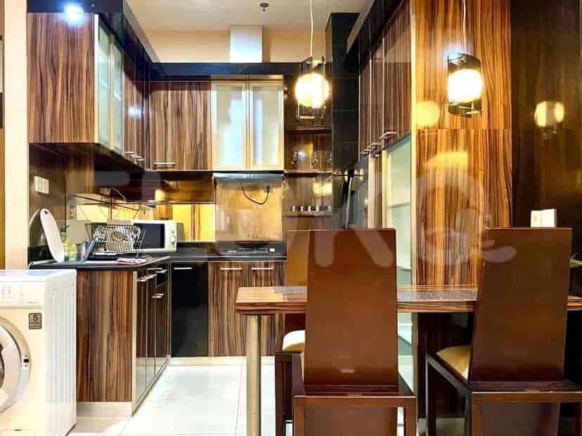 Modern kitchen with wooden cabinets, dining table, and appliances.