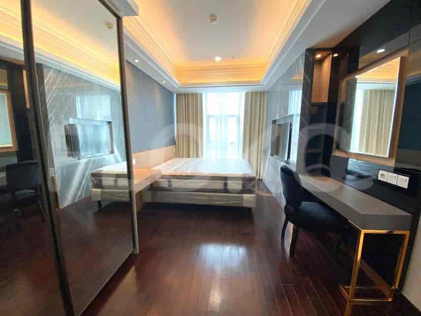 Kamar tidur dengan tempat tidur besar, meja, dan dinding cermin.