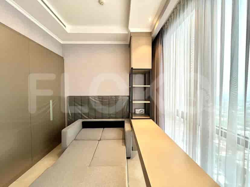 Area kamar tidur dengan sofa tarik, area meja, dan jendela besar.