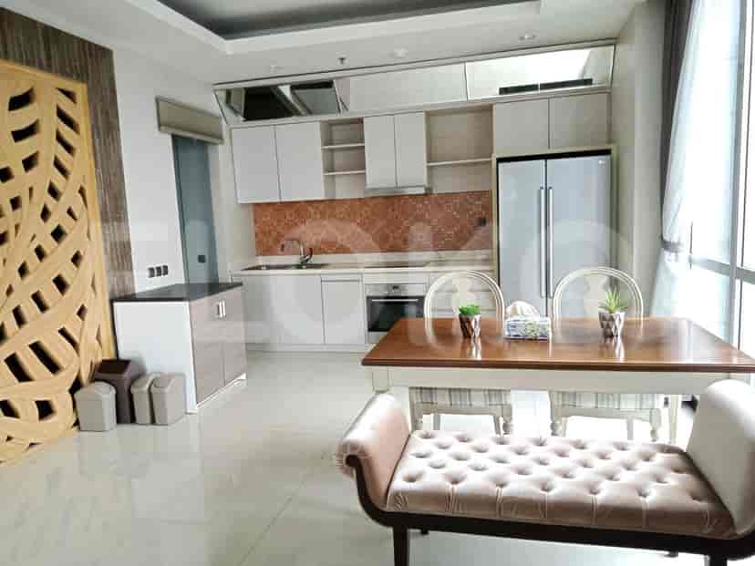 Kitchen with white cabinets, a dining table, and a refrigerator.