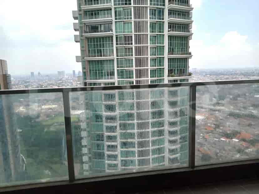 The balcony with glass railing, showing a view of the city.