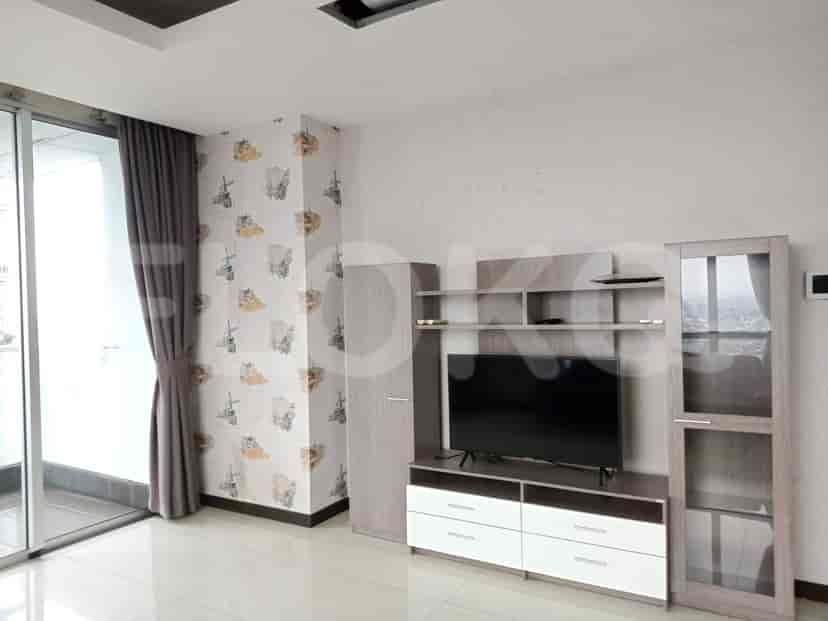 A living room with a TV unit and a glass door.