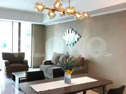 Living area with a dining table, a sofa, and a chandelier.