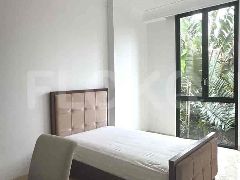 A bedroom with a single bed, a window, and a chair.