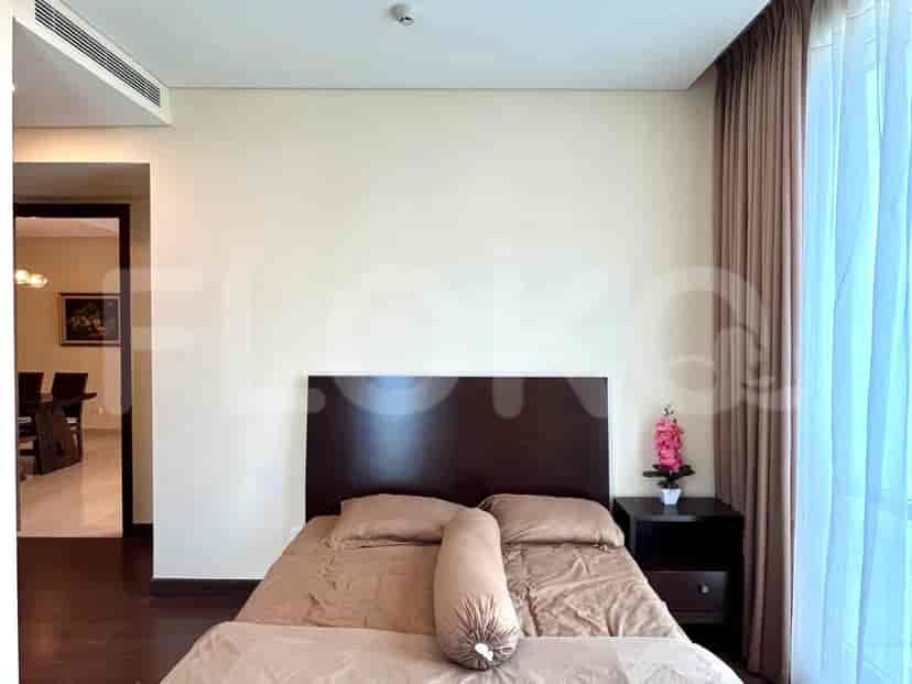 A modern bedroom featuring a bed with brown bedding, a dark wood headboard, and a nightstand.