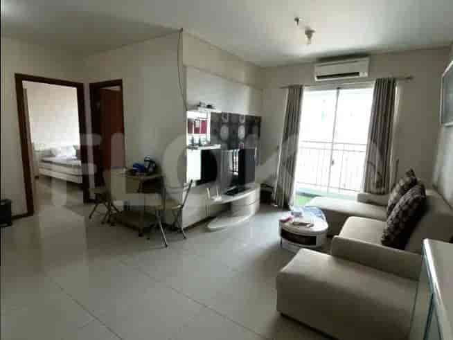 Spacious living room with L-shaped sofa, TV, and balcony access.