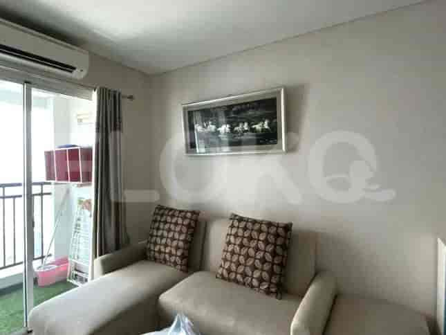 Living room with L-shaped sofa, artwork, and access to the balcony.