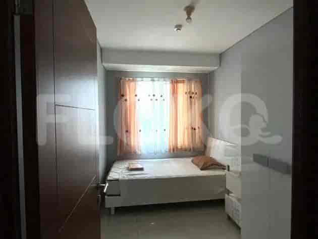 Small bedroom with a single bed, side table, and simple window treatment.