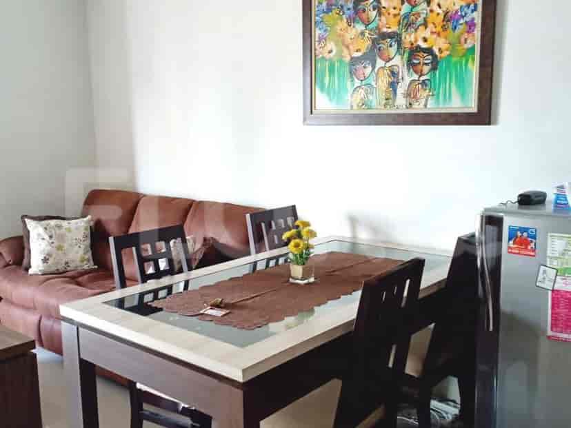 Living area with a dining table, sofa, and artwork.