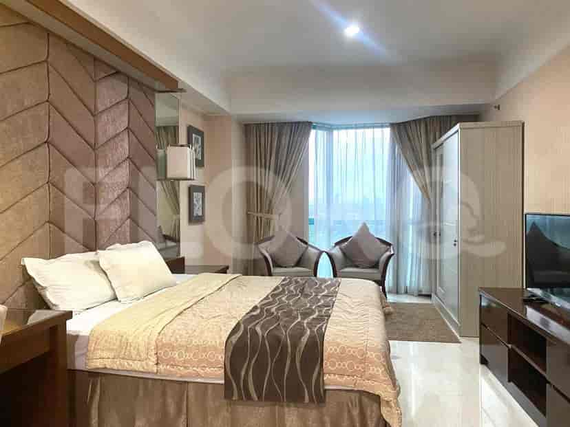 A bedroom with a bed, a wardrobe, and a TV.