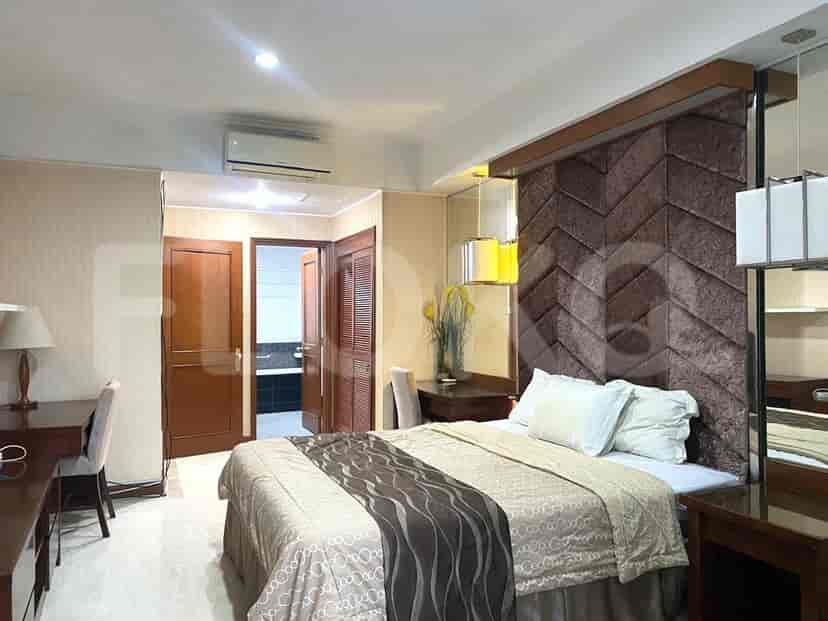 Bedroom with a bed, a desk, and a bathroom access.