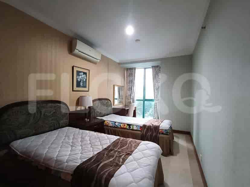 Twin beds in a bedroom with curtains.
