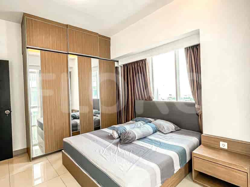 Kamar tidur yang menampilkan tempat tidur, lemari cermin, dan jendela besar.