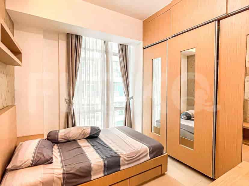 Kamar tidur yang menampilkan tempat tidur dan lemari kayu besar.