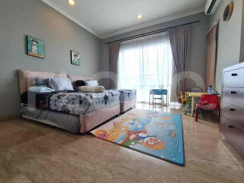 Bright children's bedroom with two single beds and a colorful playmat.