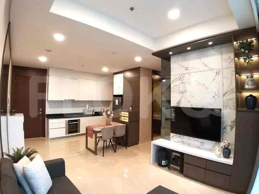 Combined living, dining, and kitchen area with white cabinets and marble accents.