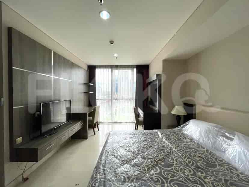 Bedroom with a bed, a TV and desk.