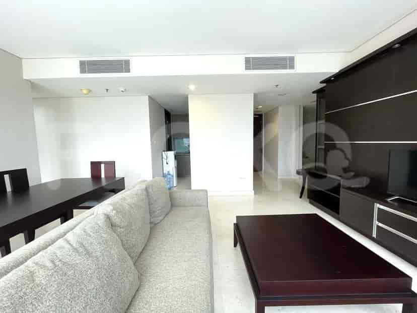A modern living room with a sofa, dining table, and a large window.