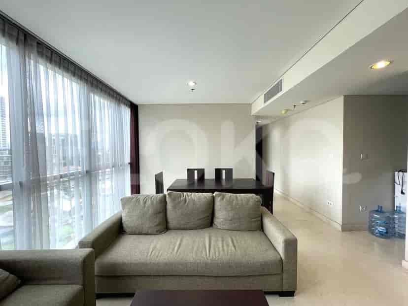 Living room showing a sofa, dining table and a large window.