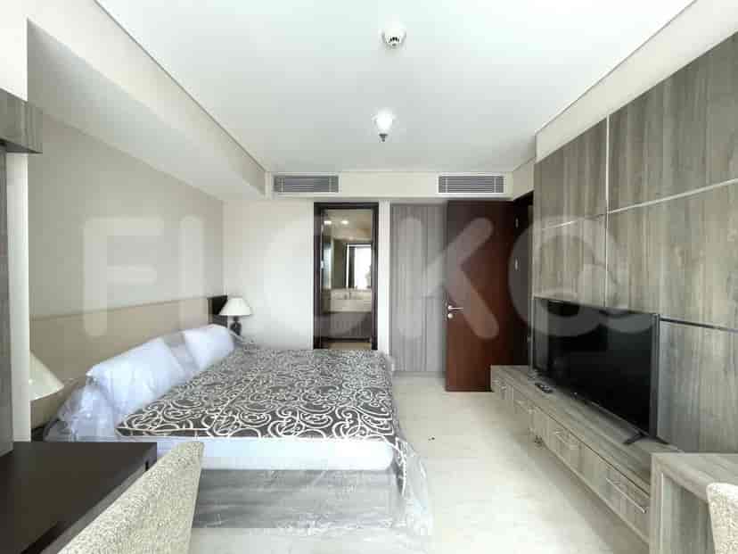 A bedroom featuring a bed, tv unit, and large window.