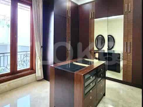 Walk-in wardrobe with dark wood cabinetry, a central island, and large mirrors.