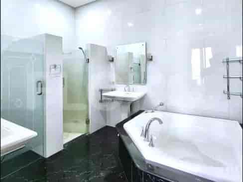 A modern bathroom featuring a standalone bathtub, glass shower enclosure, and marble flooring.