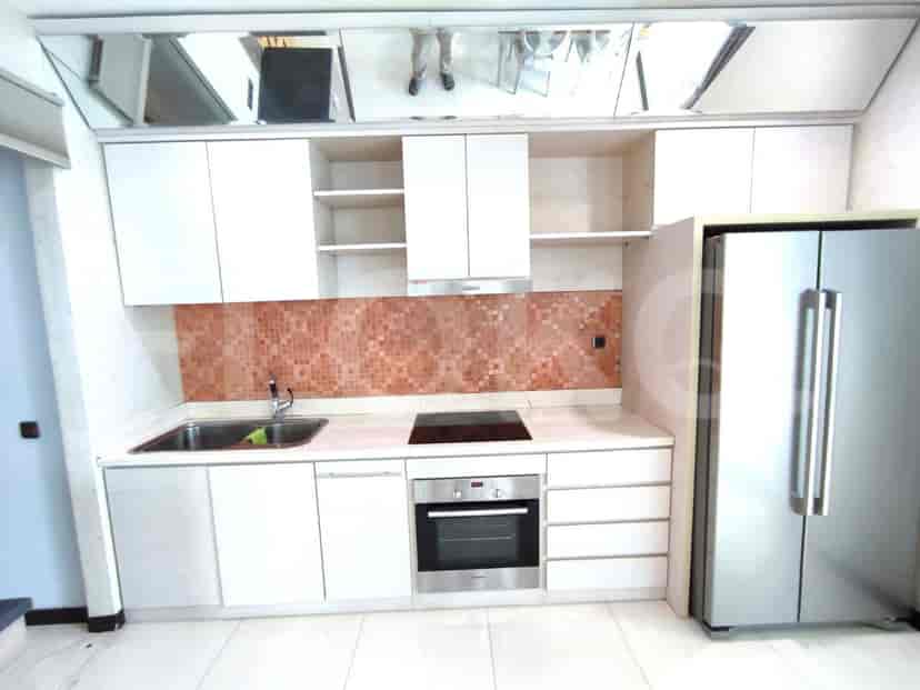 Modern kitchen with white cabinets, a stainless steel fridge, and tiled backsplash.