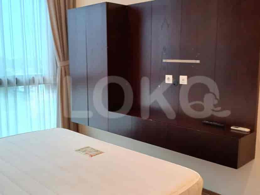 Kamar tidur dengan konsol TV, tempat tidur, dan tirai malam.