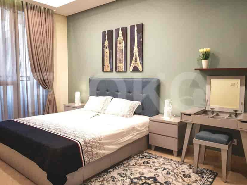A bedroom with a double bed, wall art, and a vanity area.
