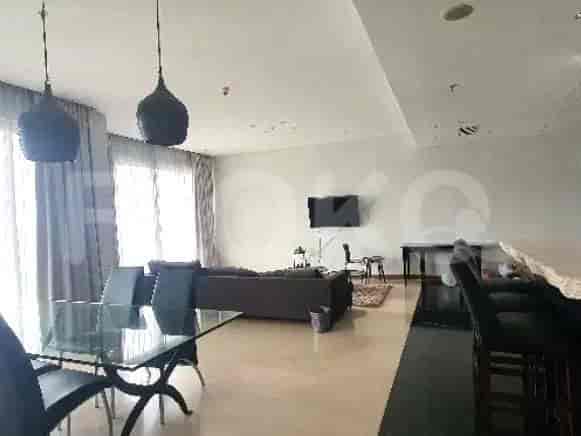 A modern living room with a dining table, L-shaped sofa, and pendant lights.