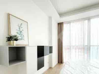 Kamar tidur yang terang benderang yang menampilkan rak gantung, seni, gorden, dan sebagian pemandangan tempat tidur.