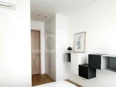 Kamar tidur dengan tata letak sederhana, menampilkan lemari, rak gantung, dan pintu tertutup.