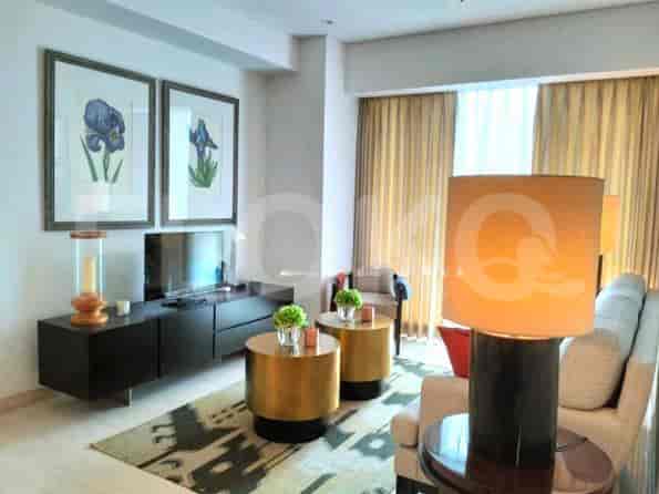 Living room with gold side tables, artwork, and a TV.