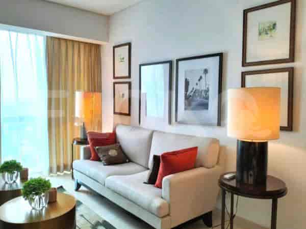 Living room with a sofa, side tables, lamps, and framed art.