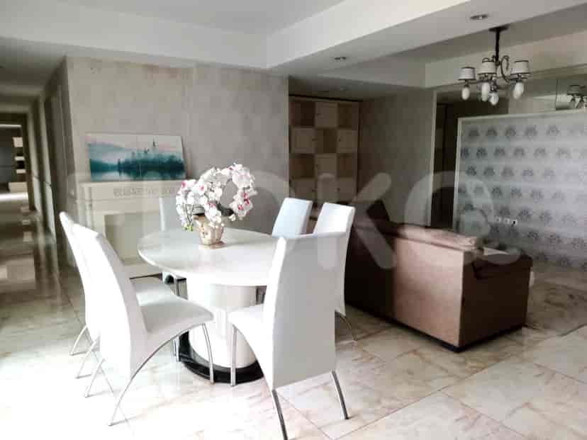 Living room with a white oval dining table, white chairs, and a decorative fireplace.