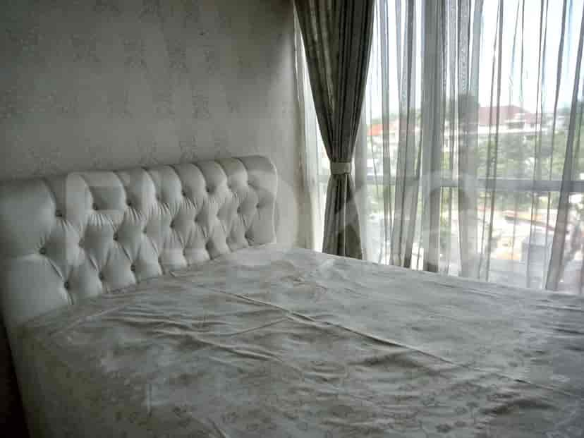 Bedroom with a white tufted headboard, large windows and curtains.