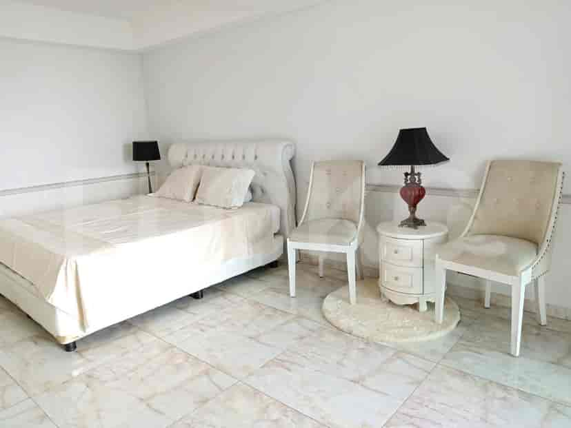Bedroom with a bed, bedside table, and chairs.