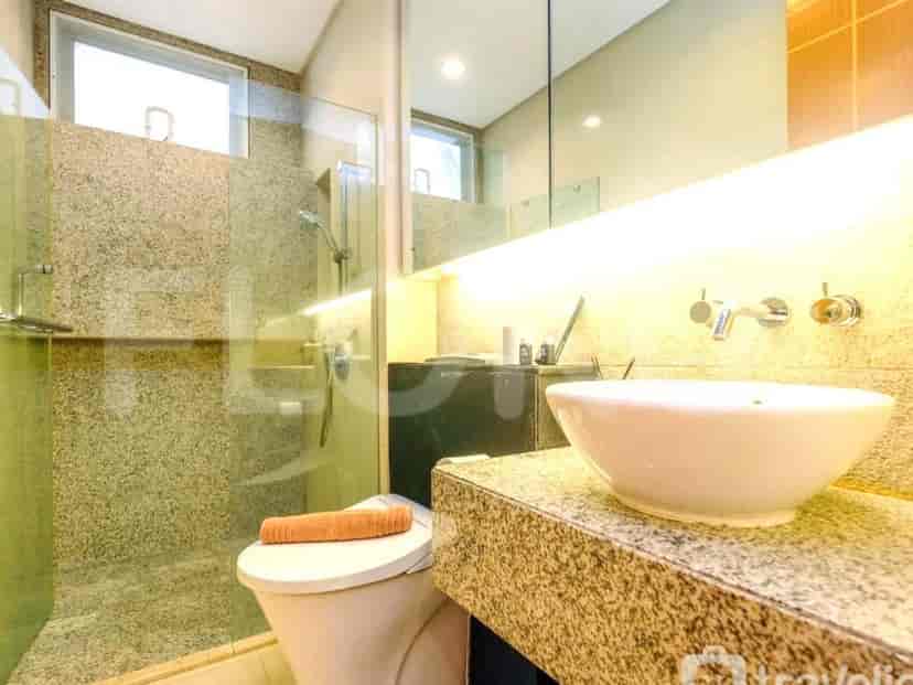 A modern bathroom with a shower, sink, and toilet.