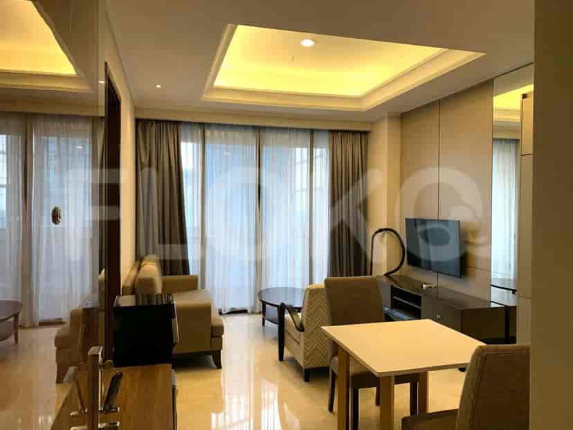 Spacious living area with a grey sofa, TV, dining area, and large windows with sheer curtains.