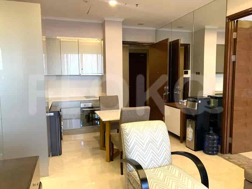 Modern kitchen and dining area with a white table, overhead cabinets, and stainless steel appliances.