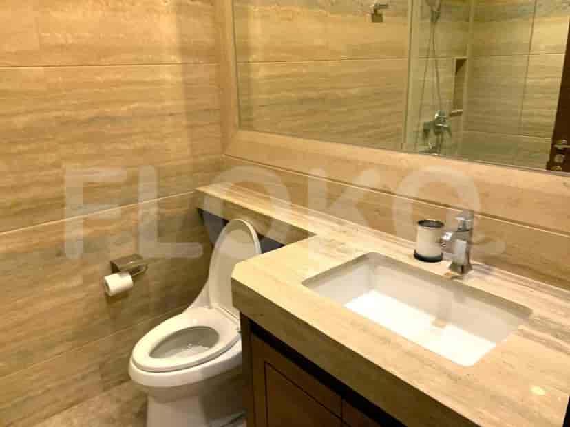Modern bathroom with a toilet, vanity, and large mirror.