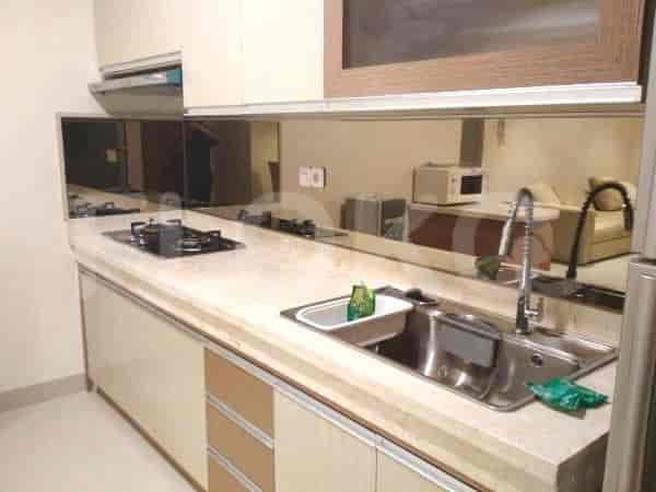Dapur modern dengan lemari, kompor gas, dan wastafel stainless steel.
